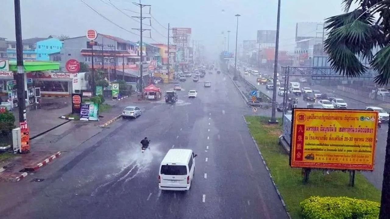 Forte pluie sur une route urbaine en Thaïlande, où des véhicules circulent sous une averse intense