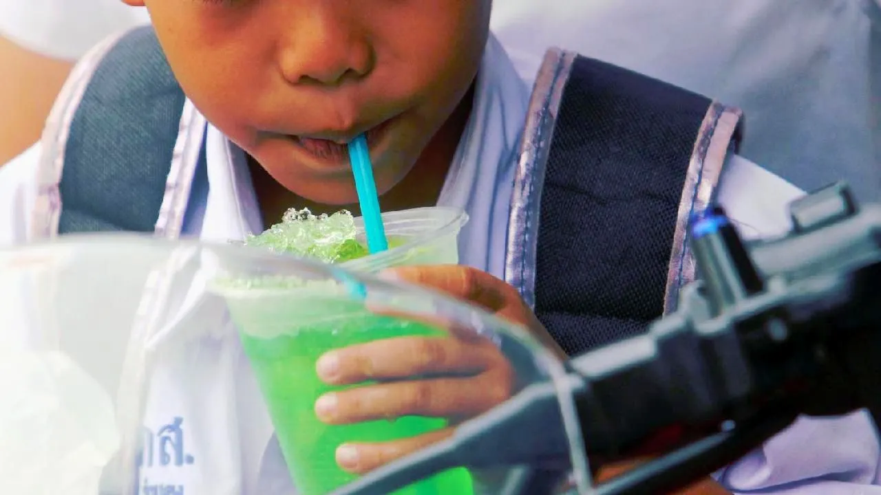 Un enfant thaïlandais avec une boisson sucrée