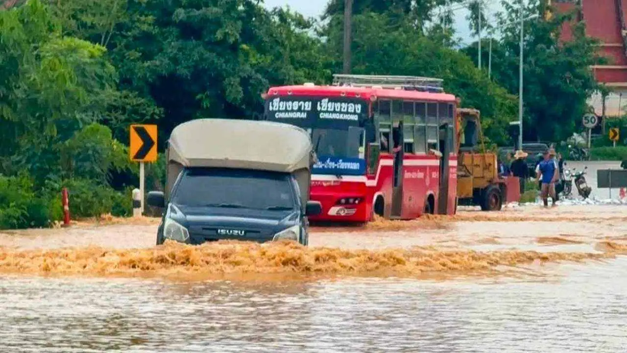 Véhicules circulant sur une route inondée dans la province de Chiang Rai