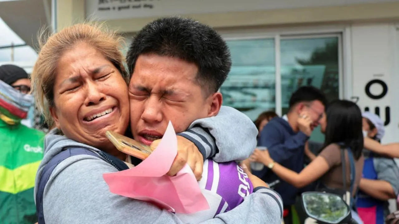 Un élève évacué de l'école Debsirin Nonthaburi réconforté par une proche après la fusillade